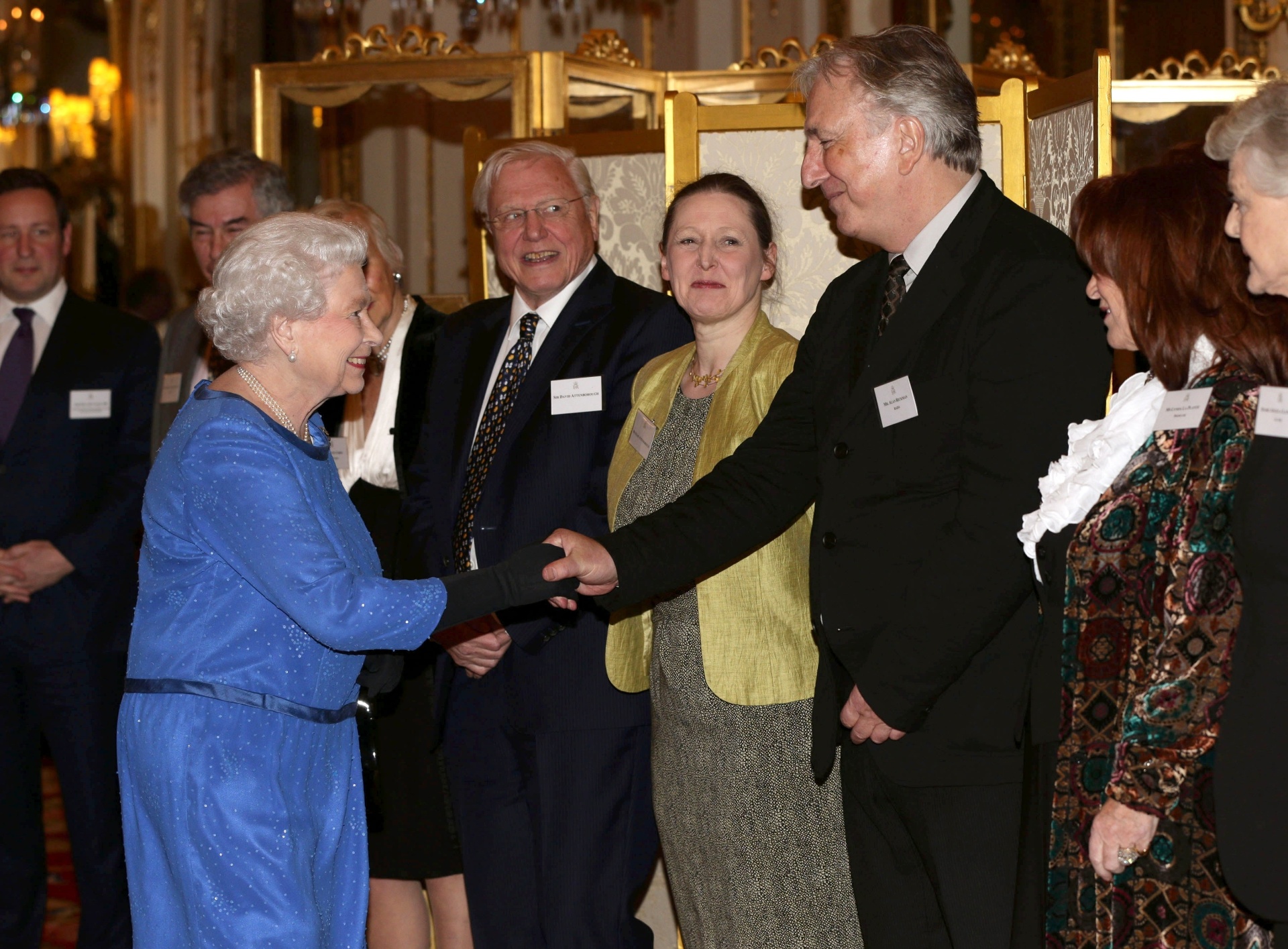 17.fev.2014 - O ator Alan Rickman cumprimenta a Rainha Elizabeth 2ª durante recepção para artistas de artes dramáticas no Palácio de Buckingham, em Londres - WPA Pool/Getty Images