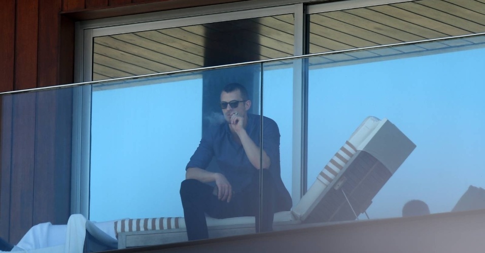 18.fev.2013 - Joel Kinnaman fuma um cigarro na sacada do hotel antes de divulgar o filme "RobCop", de José Padilha, no Rio de Janeiro