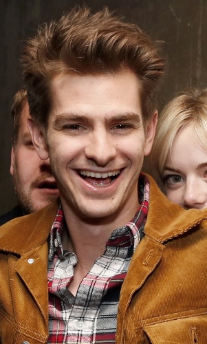 2.mai.2013 - Andrew Garfield é fotografado quando sua namorada, Emma Stone, e um rapaz aparecem ao fundo, na festa da estreia da peça "Bull at Brits" na Off Broadway, em Nova York