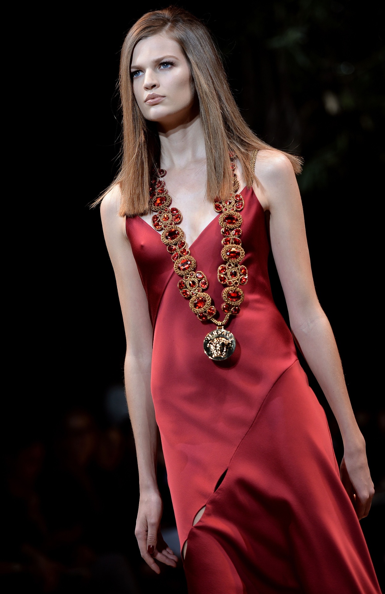 21.fev.2014 - A grife Versace apresentou uma coleção para mulheres poderosas na semana de moda de Milão. Na foto acima, modelo desfila vestido de cetim vermelho com decote generoso - AFP