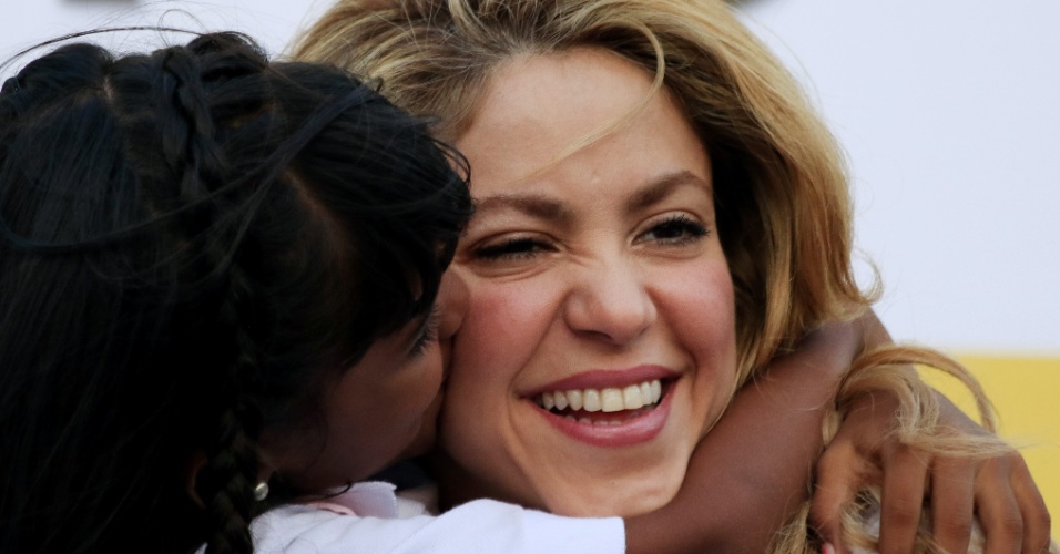 24.fev.2014 - Shakira recebe o carinho de uma criança durante a inauguração de uma escola em Cartagena, na Colômbia