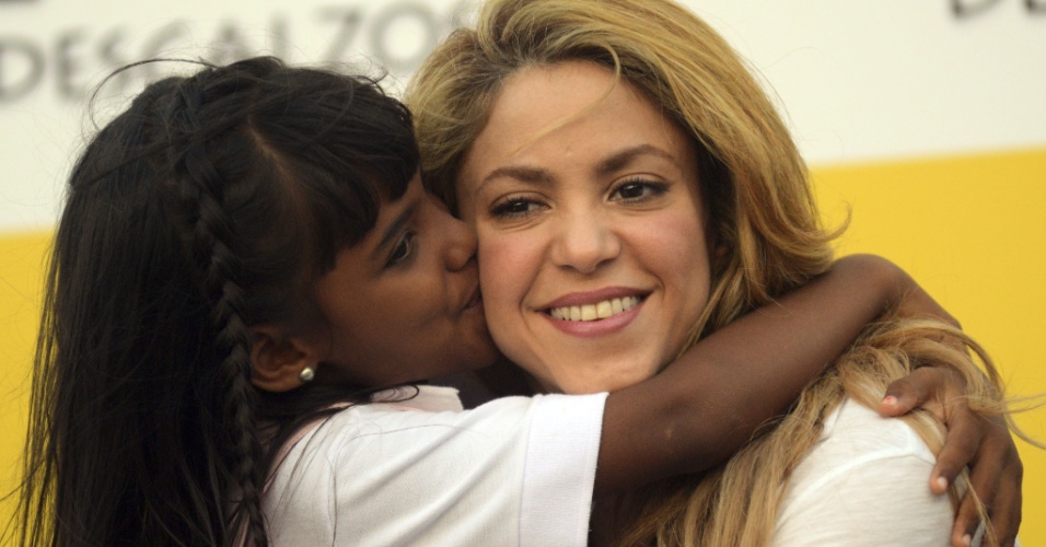 24.fev.2014 - Shakira recebe o carinho de uma criança durante a inauguração de uma escola em Cartagena, na Colômbia