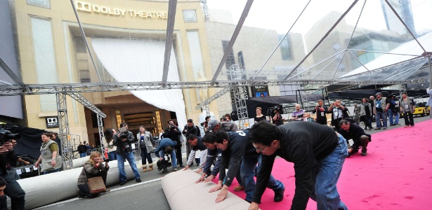 Operários desenrolam tapete vermelho ao longo da Hollywood Boulevard, em frente ao Dolby Theatre, em Los Angeles, que receberá a 86ª edição do Oscar no domingo (2) - Frederic J. Brown/AFP