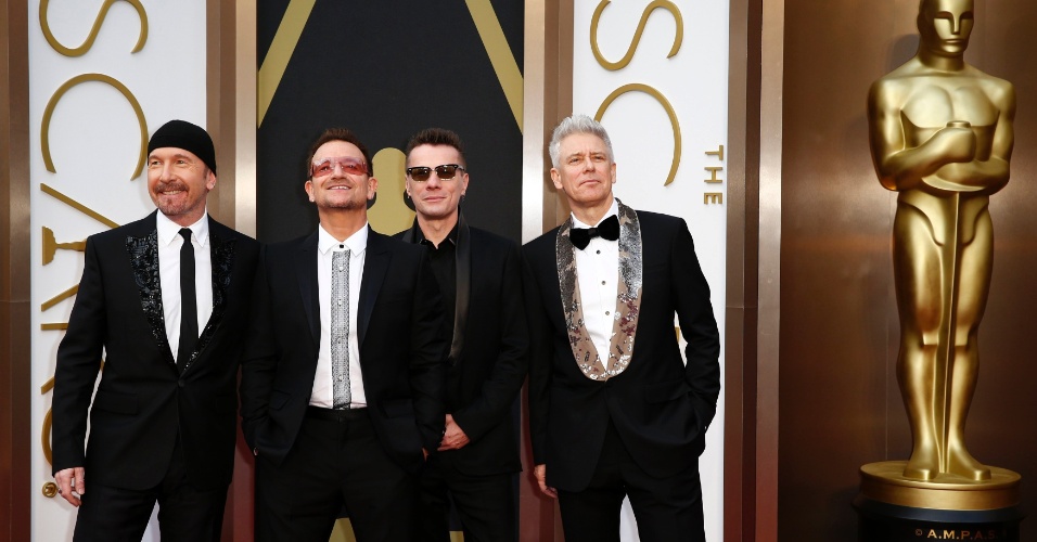2.mar.2014 - The Edge, Bono, Larry Mullen Jr. e Adam Clayton (da esq. para a dir.) chegam ao tapete vermelho. O U2 concorre ao prêmio de Melhor Canção Original por "Ordinary Love", de "Mandela: Long Walk to Freedom"