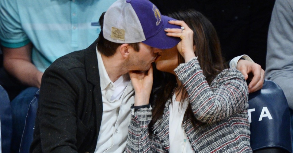 5.mar.2014- Ashton Kutcher e Mila Kunis se beijam no jogo do Los Angeles Lakers, em Los Angeles. o casal foi flagrado sorrindo no momento de lazer e a atriz exibiu seu anel de noivado