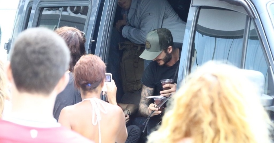7.mar.2014 - David Beckham deixa hotel no Rio de Janeiro e recebe copo açaí de fãs. Ele está no Brasil para assistir aos desfiles das escolas campeãs do Rio de Janeiro no próximo sábado (8)