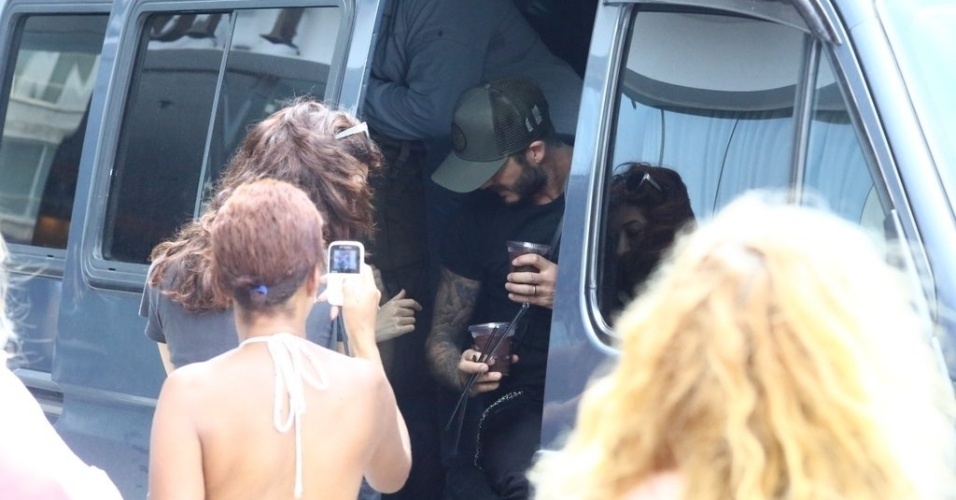 7.mar.2014 - David Beckham deixa hotel no Rio de Janeiro e recebe copo açaí de fãs. Ele está no Brasil para assistir aos desfiles das escolas campeãs do Rio de Janeiro no próximo sábado (8)