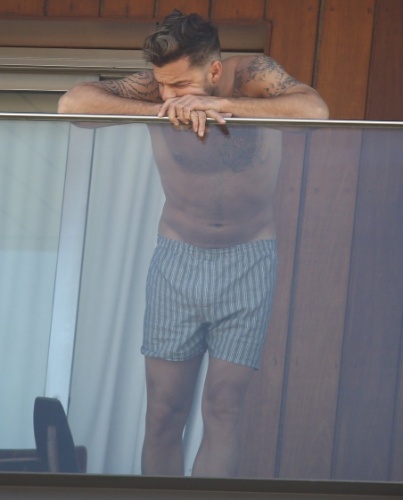10.mar.2014 - Sem camisa, Ricky Martin observa o mar e o movimento  em frente ao seu hotel na praia de Ipanema, no Rio de Janeiro