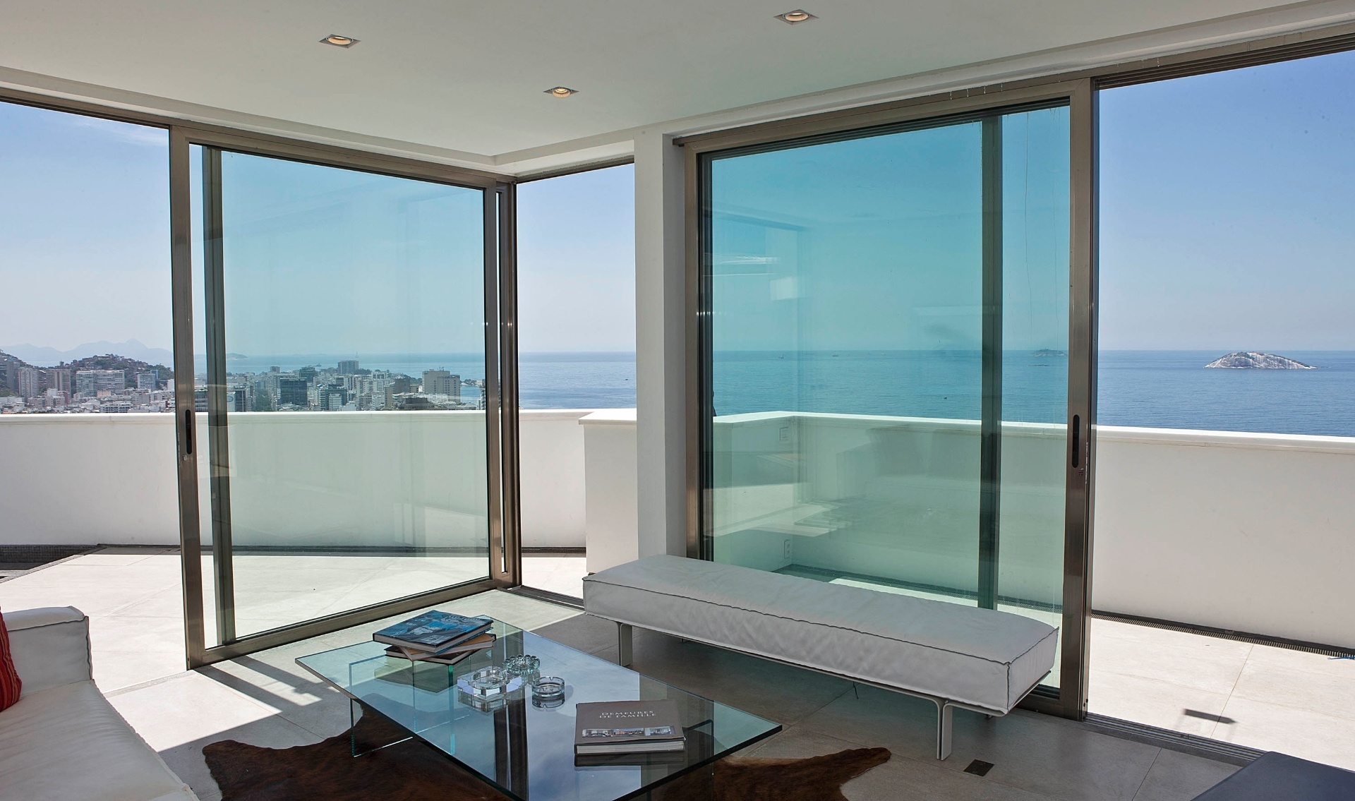 De todos os ângulos do living avista-se a paisagem do Rio. Até mesmo na quina do estar, onde as grandes portas envidraçadas de correr se encontram. A cobertura Rio Design Leblon tem projeto de reforma assinado pelo escritório House in Rio - Júlio César Guimarães/ UOL