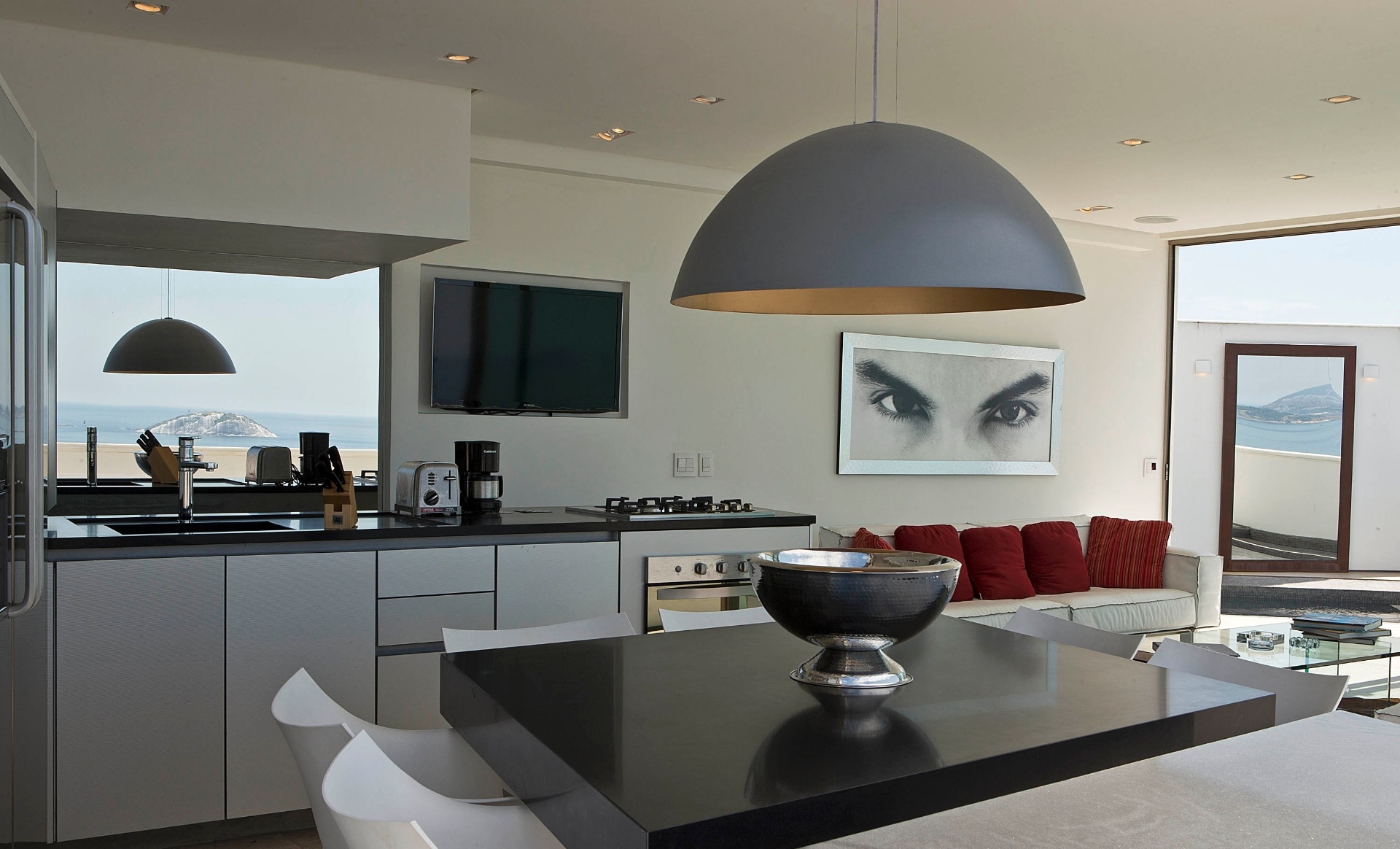 Desse ângulo, tem-se uma visão geral do living da cobertura Rio Design Leblon com os três ambientes integrados: estar, jantar e cozinha, abertos para o terraço e para o mar. A reforma do apê tem projeto assinado pelo escritório House in Rio - Júlio César Guimarães/ UOL