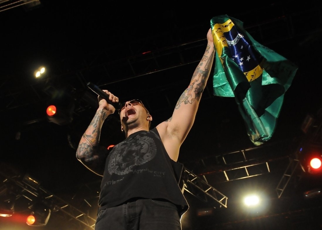 12.mar.2014 - O vocalista M. Shadows ergue bandeira do Brasil em show do Avenged Sevenfold no Espaço das Américas, em São Paulo - AgNews