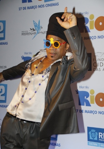 18.mar.2014 - O cantor Carlinhos Brown faz caras e bocas e também dança para os fotógrafos na première do filme "Rio 2" na Cidade das Artes na Barra da Tijuca, no Rio de Janeiro