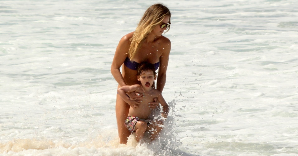 27.mar.2014 - Letícia Birkheuer brinca no mar com o filho, João Guilherme, em Ipanema, no Rio de Janeiro