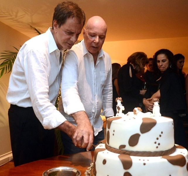 23.mar.2014 - O autor Gilberto Braga corta o bolo de seu casamento com Edgar Moura Brasil, seu companheiro há 40 anos.