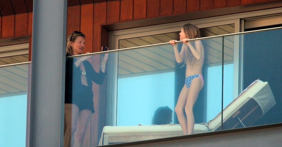 2.abr.2014 - Com o celular, Kate Moss tira foto da filha Lila Grace na sacada do hotel Fasano, no Rio de Janeiro. A top está no Brasil o baile de gala da amfAR, que acontece no dia 4