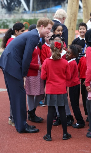 4.abr.2014 - Príncipe Harry conversa com grupo de crianças durante visita oficial ao Queen Elizabeth Olympic Park, em Londres