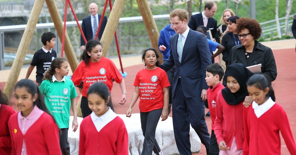 4.abr.2014 - Príncipe Harry se diverte com crianças durante visita oficial ao Queen Elizabeth Olympic Park, em Londres