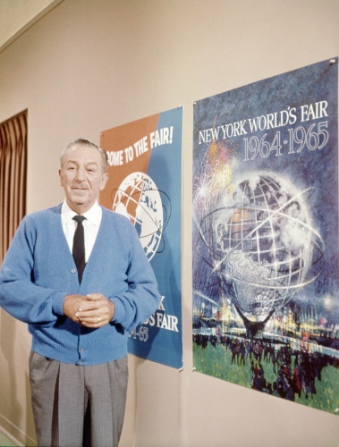 Em foto de 1964, Walt Disney posa ao lado cartazes da Feira Mundial de Nova York