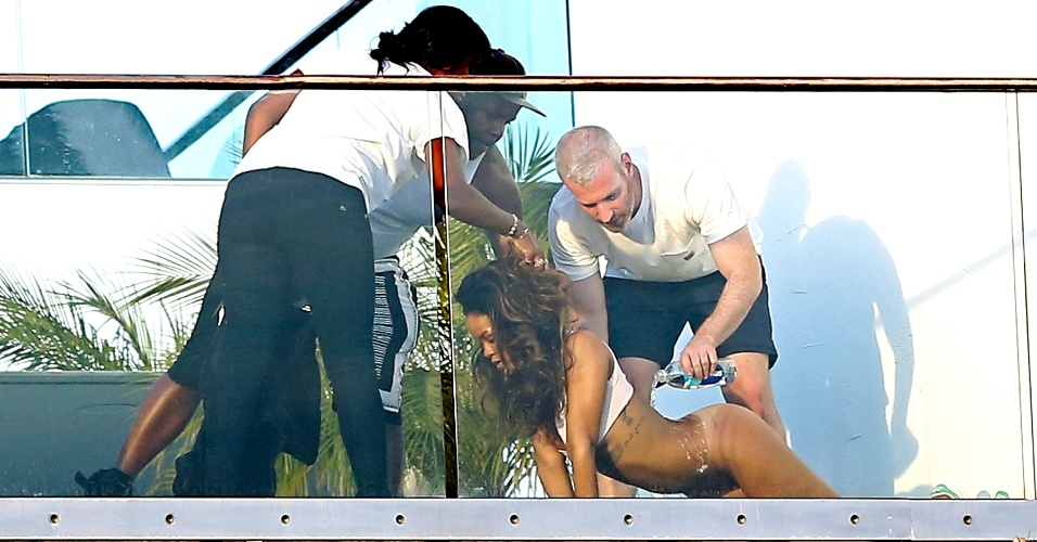 8.abr.2014 - Sem calcinha e com o bumbum à mostra, Rihanna recebe preparos para fazer ensaio sensual. A cantora posou na sacada de um prédio em Hollywood, na Califórnia, e exibiu cabelos mais longos