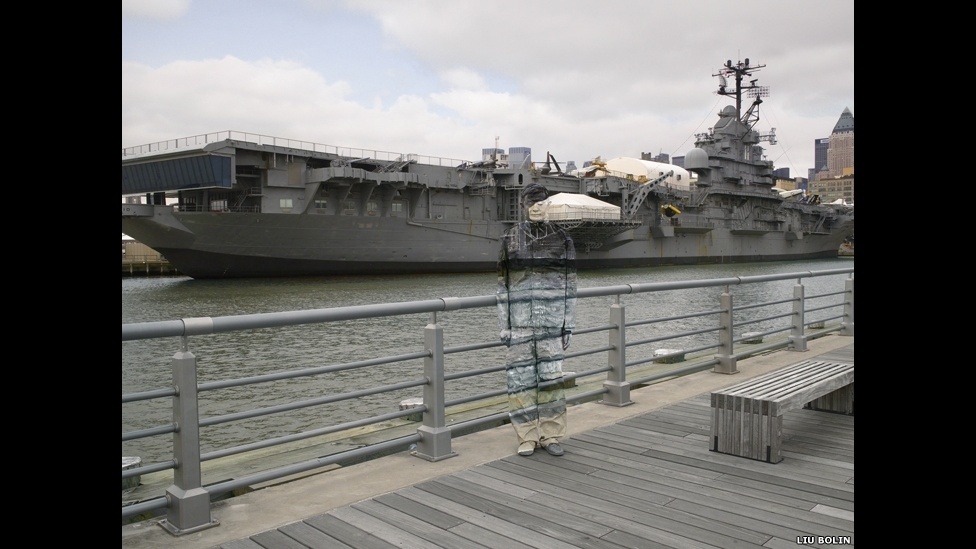 se camufla em meio às paisagens que deseja retratar, desde prateleiras de supermercado a estantes de biblioteca - ©Liu Bolin/Scream Gallery