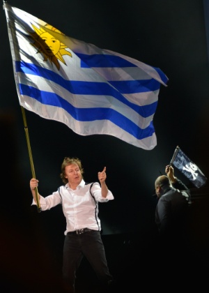 19.abr.2014 - Com a bandeira do Uruguai, Paul McCartney abre a etapa sul-americana de sua turnê "Out There!" em Montevidéu - Mariana Suarez/AFP Photo