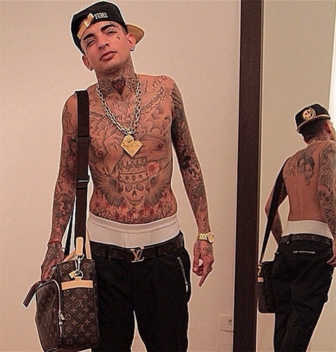 Com o sucesso na carreira, o visual de MC Guimê evoluiu das marcas de surfe para o luxo francês. Na foto tirada durante ensaio com JR Duran, ele combina bolsa e cinto Louis Vuitton - Reprodução/Instagram