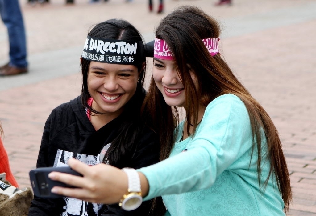 25.abr.2014 - Duas fãs do One Direction aguardam abertura dos portões do estádio El Campím, em Bogotá, para o show do grupo - Leonardo Munhoz/EFE