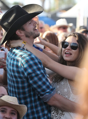 27.abr.2014 - Ashton Kutcher e Mila Kunis dançam e cantam juntos em festival de música country na Califórnia. O casal, que espera sua primeira filha, se conheceu nos bastidores do seriado "That's 70's Show"