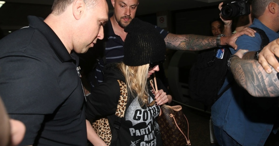 28.abr.2014- Avril Lavigne é cercada por seguranças ao chegar ao Brasil