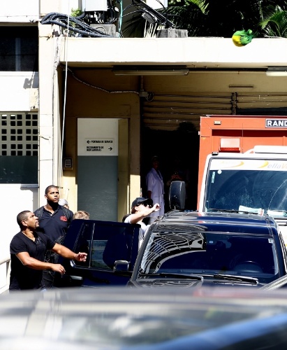 29.abr.2014 - Enquanto Demi Lovato entra em carro para deixar hotel no Rio de Janeiro, fã arremessa objeto enrolado na bandeira do Brasil em direção à cantora