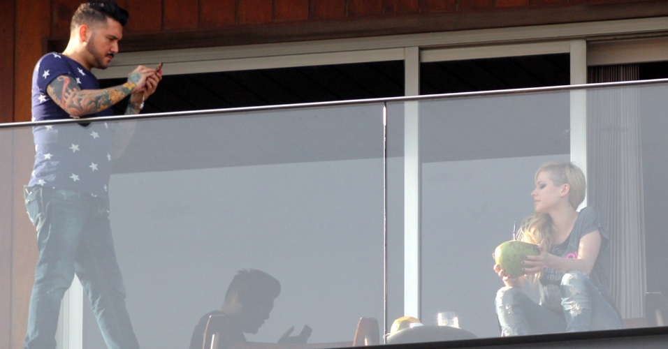 2.mai.2014 - Avril Lavigne apareceu bebendo água de coco na sacada do hotel onde está hospedada, no Arpoador, zona sul do Rio de Janeiro