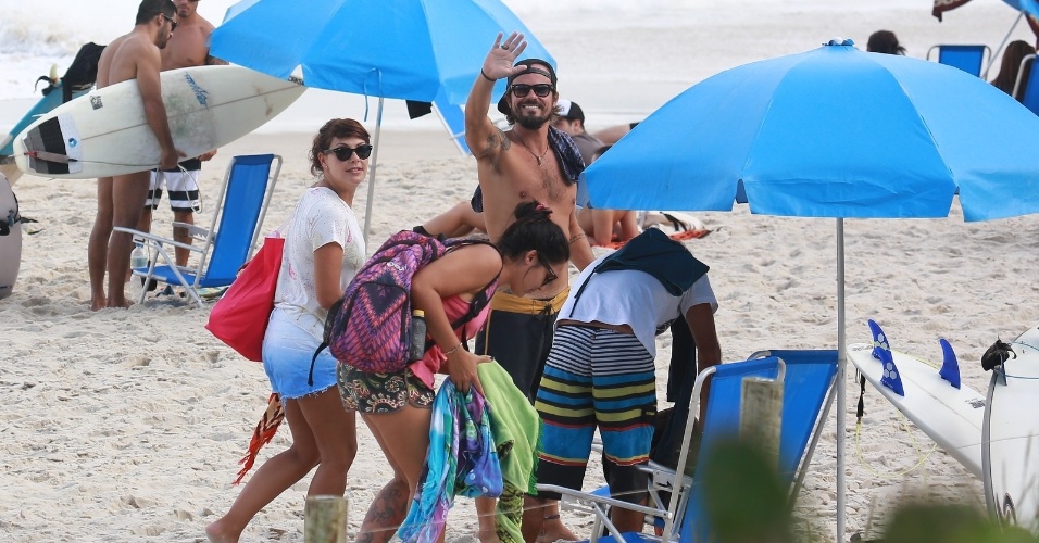 2.mai.2014 - Com turma de amigos, incluindo a atriz Fabíula Nascimento, o ator Paulinho Vilhena acena para fotógrafo na Prainha, no Rio de Janeiro