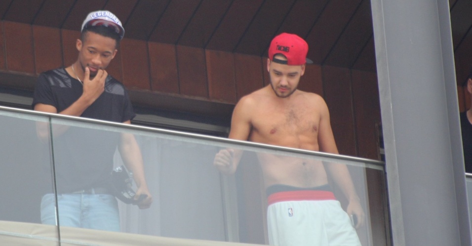 7.mai.2014 - De boné e sem camisa, Liam Payne aparece na sacada do hotel Fasano, no Rio