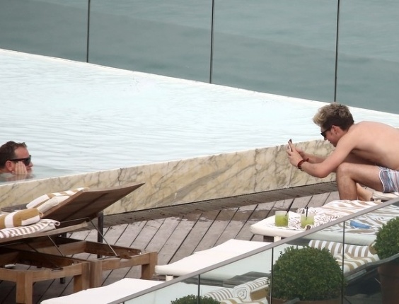 7.mai.2014 - Niall Horan, do One Direction, tira foto à beira da piscina do hotel, no Rio de Janeiro