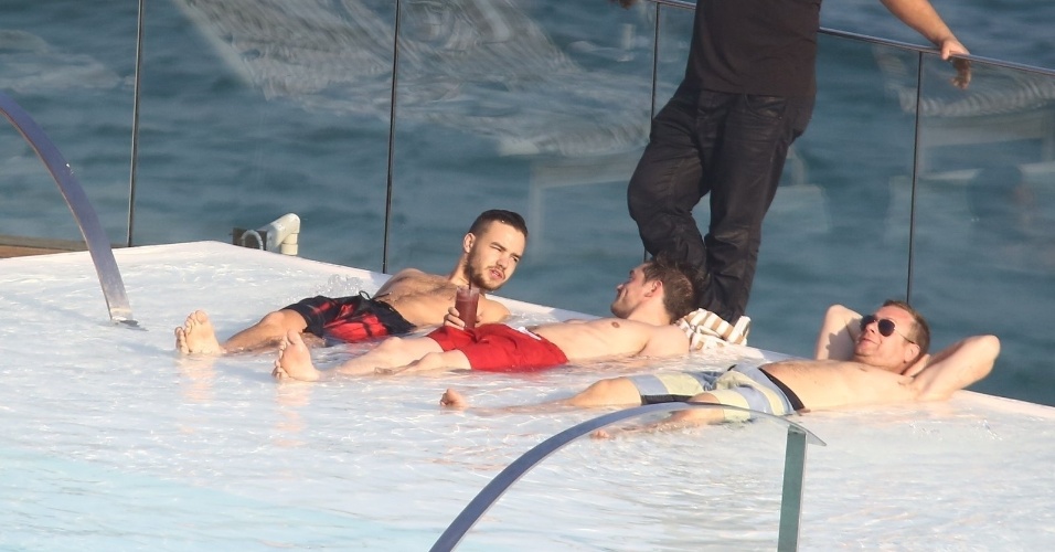 8.mai.2014 -  Membros do One Direction conversam enquanto tomam sol na piscina do hotel em que estão hospedados na zona sul do Rio
