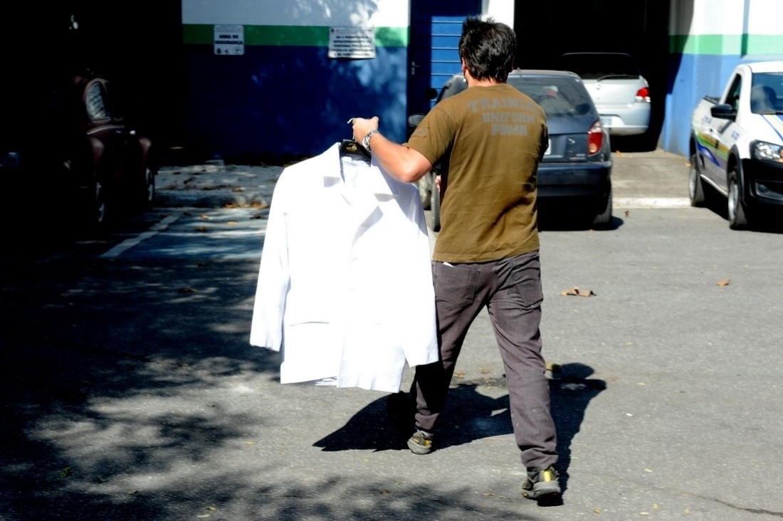 8.mai.2014 - Parente de Jair Rodrigues chega ao IML de Cotia, onde o cantor morava, com o terno branco com o qual o artista será velado na Assembleia Legislativa de São Paulo - Francisco Cepeda/AgNews