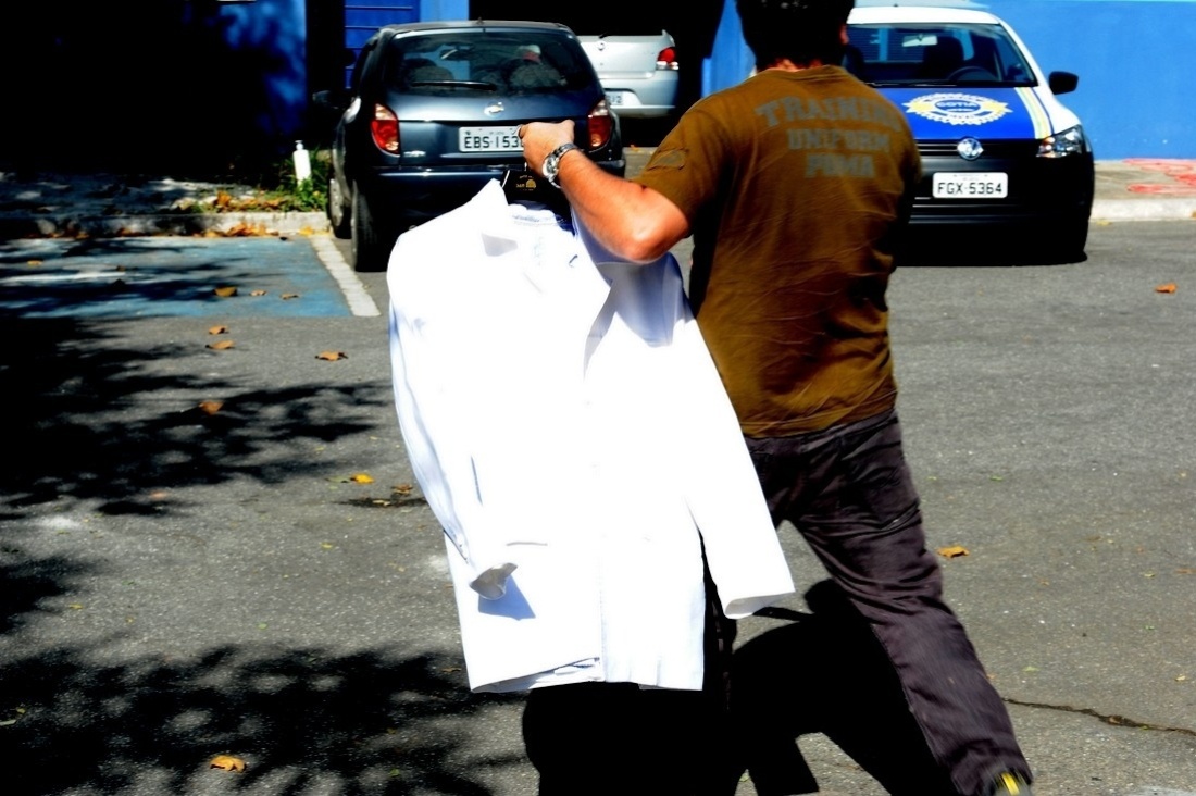 8.mai.2014 - Parente de Jair Rodrigues chega ao IML de Cotia, onde o cantor morava, com o terno branco com o qual o artista vai ser velado na Assembleia Legislativa de São Paulo - Francisco Cepeda/AgNews