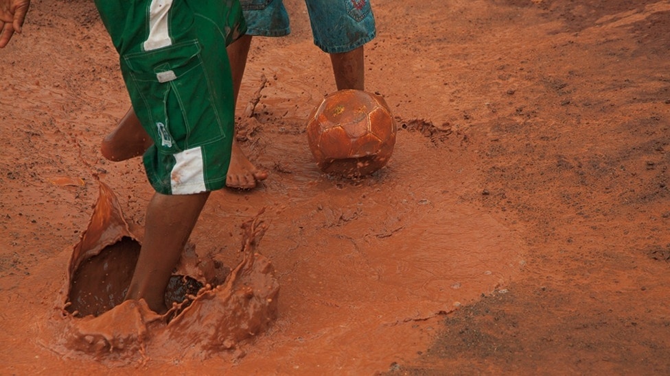 "É o futebol jogado com o coração", acrescenta Vilela. Acima, dois jovens jogam futebol em um campo de lama na Área de Proteção Ambiental Fazendinha, no Pará - Caio Vilela/Divulgação BBC