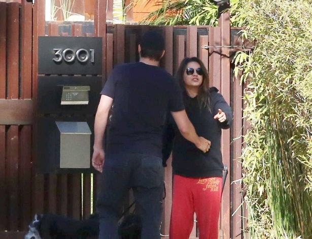 Mila Kunis se irrita com fotógrafo e Ashton Kutcher tenta fazê-la voltar para dentro da casa do casal em Los Angeles, na Califórnia