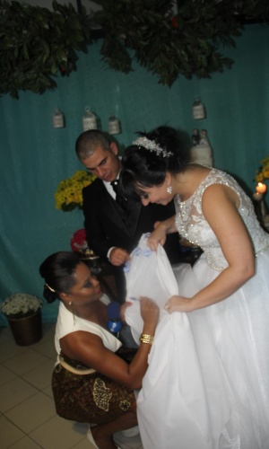 16.mai.2014 - Adriana Bombom escreveu seu nome na barra do vestido da noiva, Luciana Picorelli