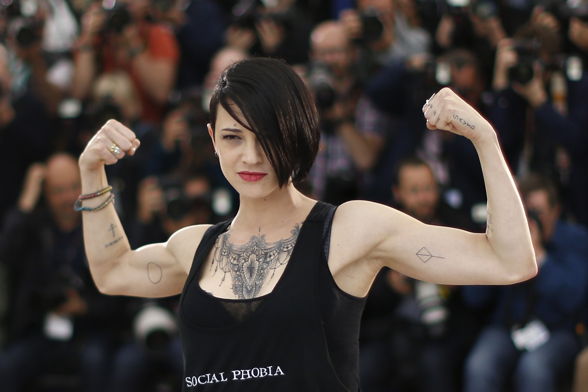 22.mai.2014 - Asia Argento mostra tatuagens e músculos em Cannes. A atriz levou ao festival sua nova aventura na direção com o filme "Incompresa" - AFP