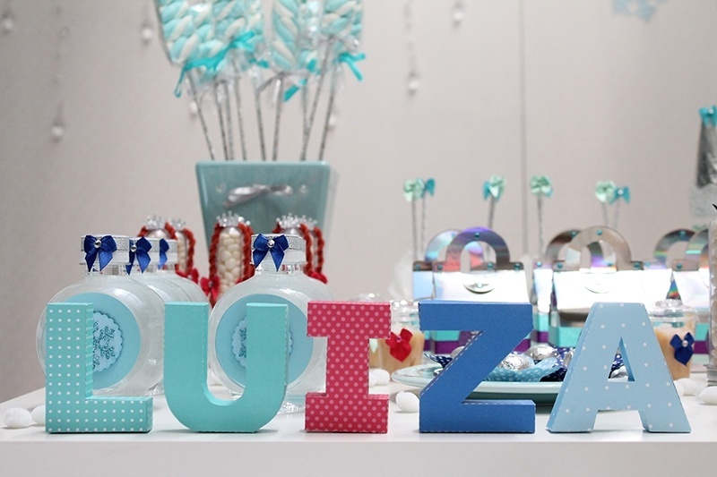 Com o primeiro nome em comum, e colocado em um painel, as três irmãs donas dessa festa de aniversário com tema "Frozen" tiveram seus segundos nomes representados em cima da mesa do bolo - Tatiana F. Martins/Divulgação