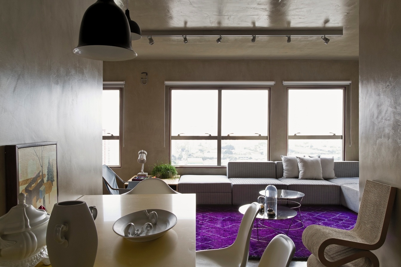 Ocupando toda a extensão de uma das paredes do living, as janelas garantem a entrada de luz natural para os espaços sociais do loft Vila Leopoldina, favorecendo estar, jantar e parte da cozinha. No teto, o trilho com spots e pendentes, da Bertolucci, corre em duas direções: sobre a mesa de jantar e no centro do estar. O projeto de reforma leva a assinatura do arquiteto Diego Revollo - Alain Brugier/ Divulgação