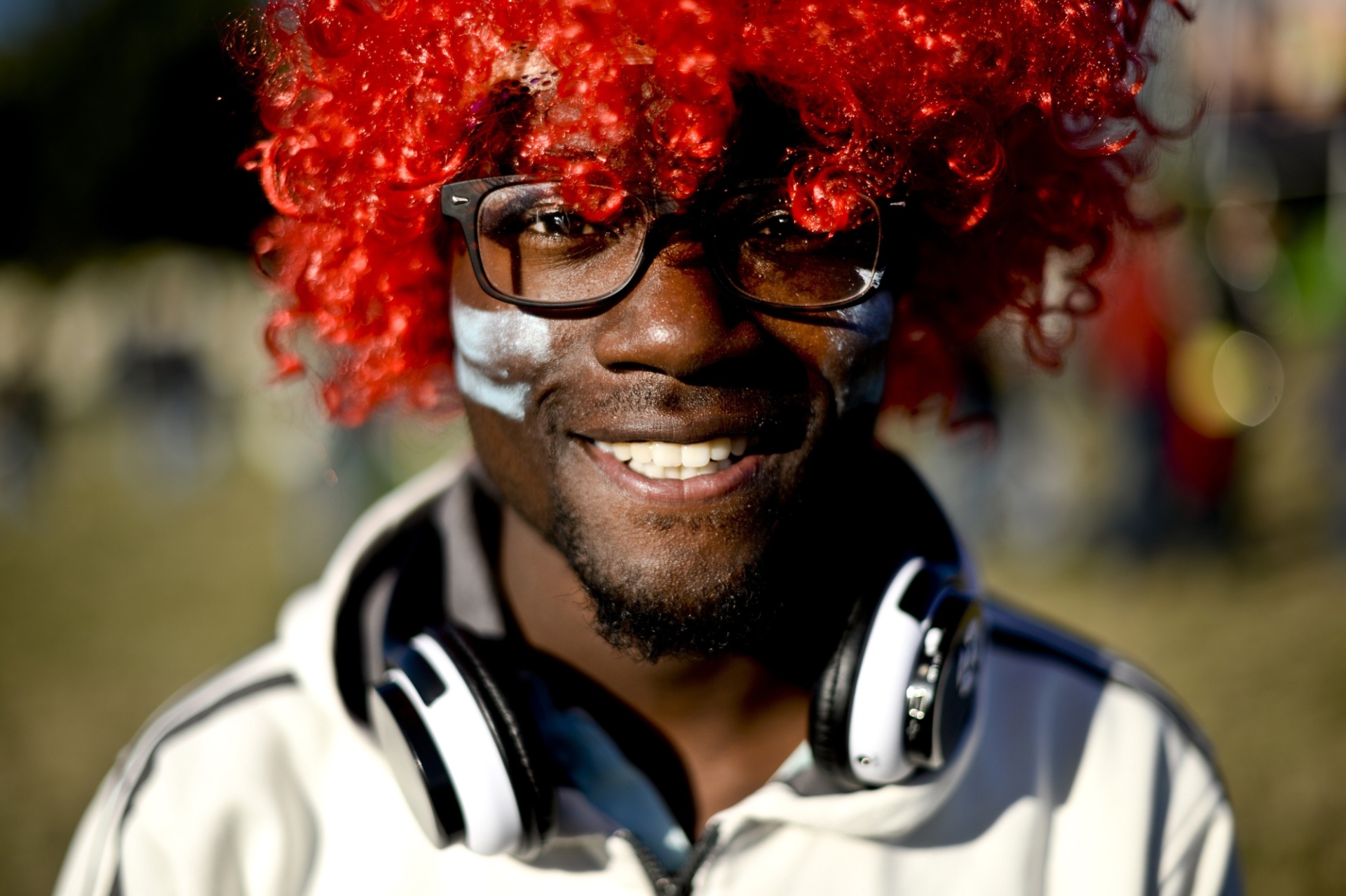 25.mai.2014 - Garoto curte o festival usando peruca vermelha e com o rosto pintado - AFP