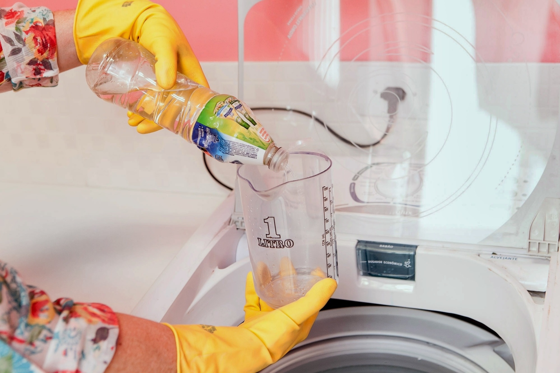 Assim que a lavadora estiver em movimento, despeje um litro de vinagre de álcool dentro do tambor da máquina ou no compartimento dedicado ao sabão. Espere alguns segundos para os compostos se misturarem e pause o ciclo de lavagem da máquina por cerca de 30 minutos - Rodrigo Capote/UOL