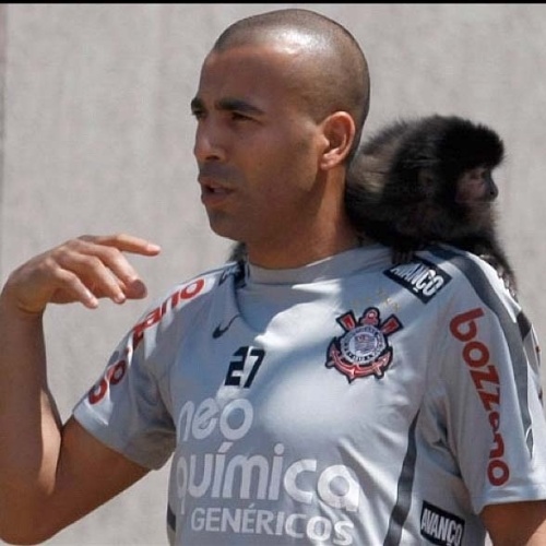 O jogador de futebol Sheik posa com sua macaca Cuta no CT do Corinthians