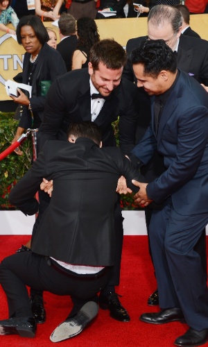 18.jan.2014 - O repórter ucraniano Vitalii Sediuk entra no tapete vermelho e se joga aos pés de Bradley Cooper durante o SAG Awards (Screen Actors Guild). O homem é conhecido por fazer pegadinhas em uma emissora de televisão ucraniana