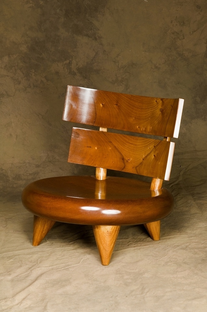 Cadeira Cuica, de Carlos Motta. Baixa, robusta e elegante, a cadeira é toda feita de madeira - Divulgação