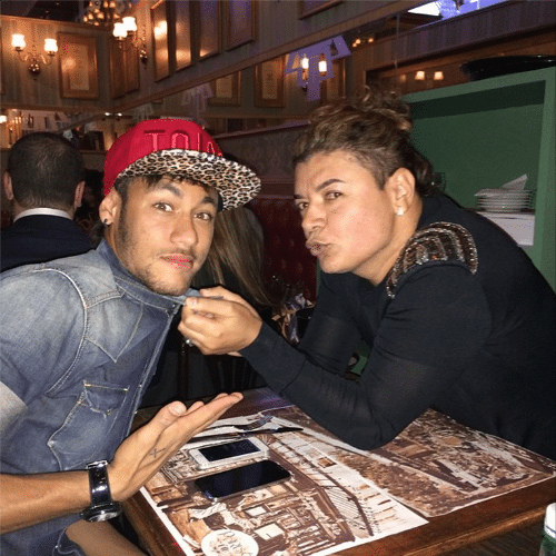 6.jun.2014 - David Brazil tenta dar um beijo em Neymar no jantar de lançamento de um restaurante em São Paulo