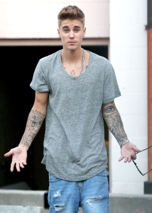 Bieber é visto em raro momento de bom humor com paparazzi, ao deixar restaurante em Los Angeles